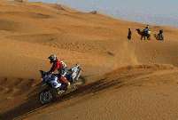BMW mounted Nick Plumb rides past some interested locals during the 2004 Dakar.